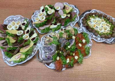 Vier dekorative Platten mit belegten Broten, Fisch, Käse, Eiern, Salat und Garnitur auf Spitzendeckchen